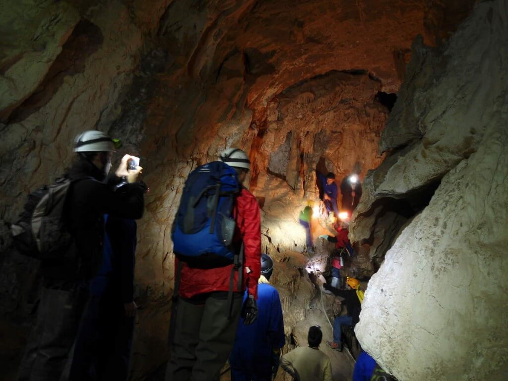 Grupo de personas explorando la cueva Peña Miel
